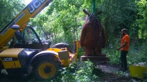 Artist Dan (right) watches the Gruffalo being lifted into position on the trail