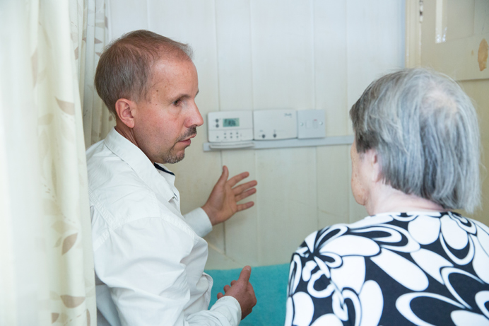 Mr Horgan's carer is shown how to use the new heating system by an advisor