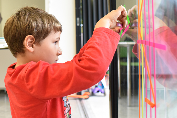 Boy adding tape to the window at the Rickyard during the Big Draw