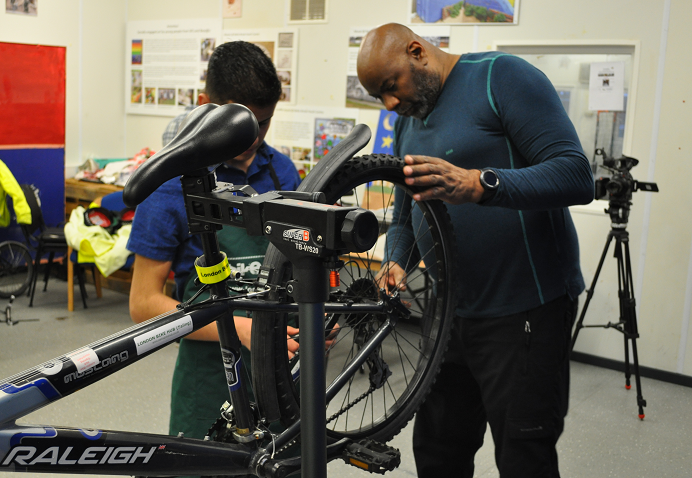 man fixing a bicycle's flat tire