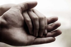 coping with grief adult hand and child hand b&w