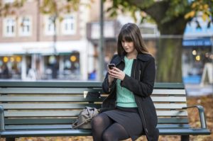 Woman sitting on a bench in a public space in Ealing