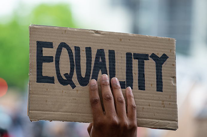 Cardboard sign with equality written on it