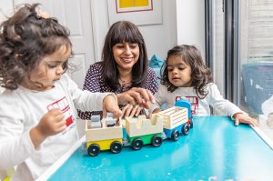 Simmi Bajaj, co-founder of Ealing Toy Library, playing with one of the toys with her daughters