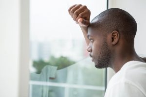 mental health - man looking thoughtfully out of a window