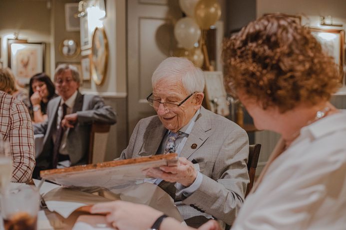 Older person opening presents at a celebration