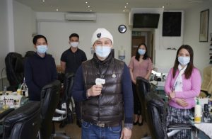 People with facemasks in nail bar