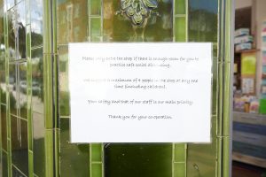 Shop displaying notice of new COVID safety measures