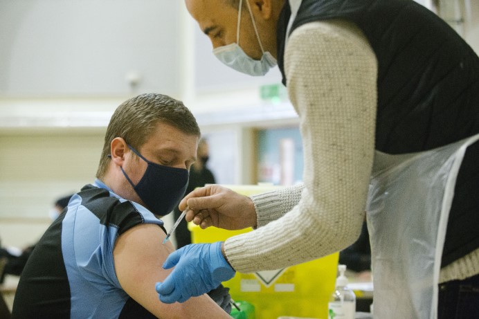 Man receiving a coronavirus vaccination in the arm