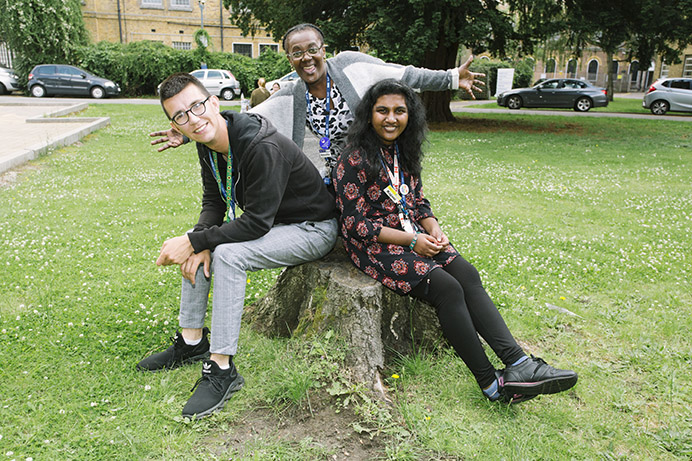 Sitting outside together on a tree stump: Project Choice: Student Aaron Parker, Annette Lafitte the project co-ordinator and student Kajani Ambikaiplan