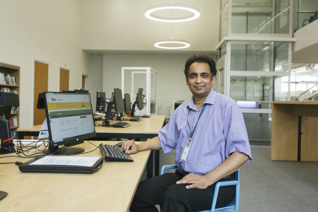Man at computer desk inside library
