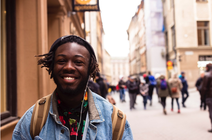 Young black man looking optimistic and happy in a high street