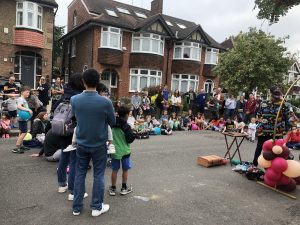 People watching a children's entertainer at street party