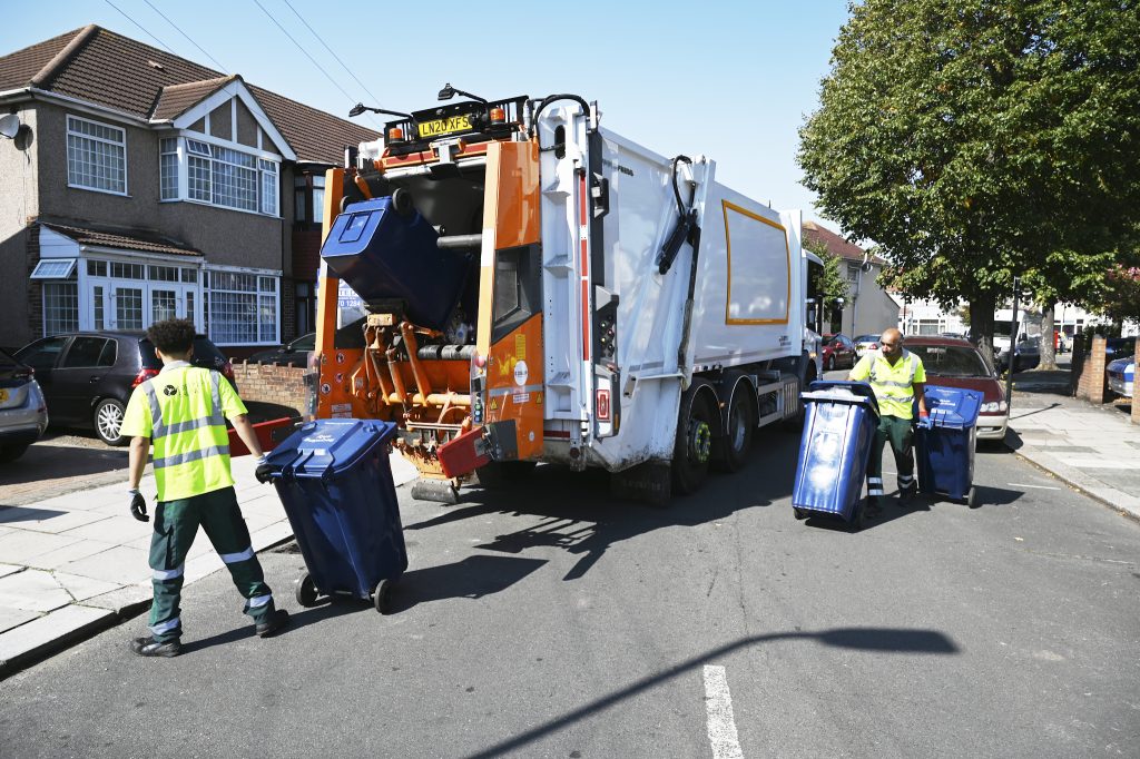 Recycling truck and bin collectors in a street collecting recycling from bins