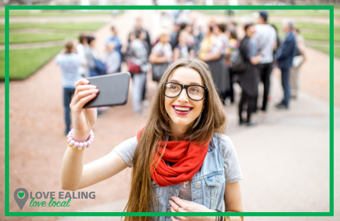 girl taking a selfie with blurred walking tour group in background