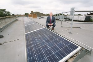 Grange Primary School headteacher Jamie Maloy on the roof next to solar panels