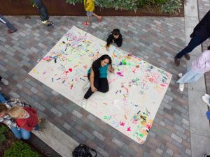 Woman sitting on giant artwork