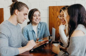 Young people sitting around a table and talking