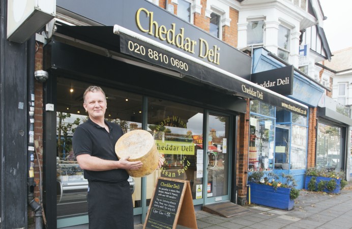 Brent Wilkinson, owner of Cheddar Deli outside his shop holding cheese