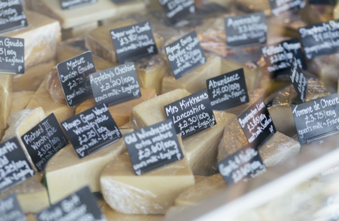 close up of different types of cheese in deli window