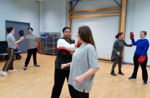 Women in a sports hall doing self defence moves