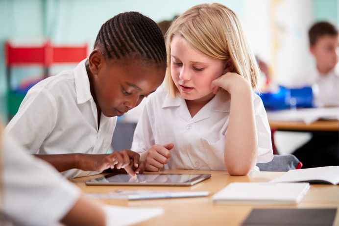 Primary school children - a boy and a girl - working at a desk