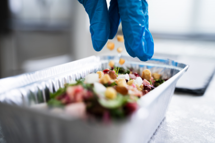 Worker adding ingredients into a container