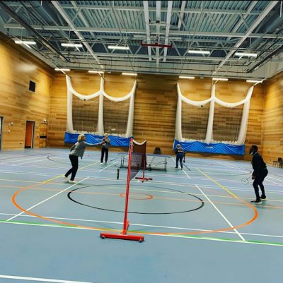 People playing badminton in a sports hall