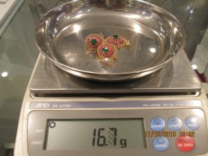 Jewellery being weighed on a set of scales