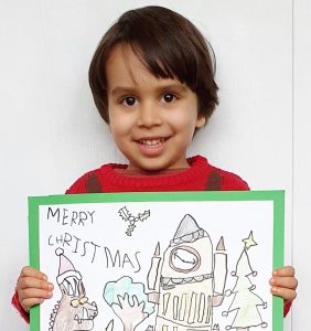 Mason Dalton (male) holding his Christmas card entry design