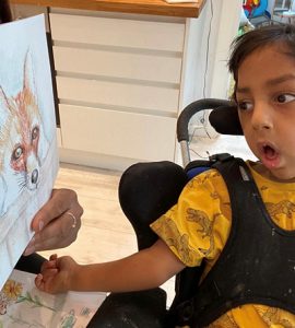 A boy looking at an illustration of a fox