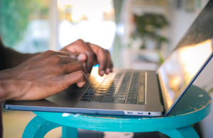 A man typing into a laptop
