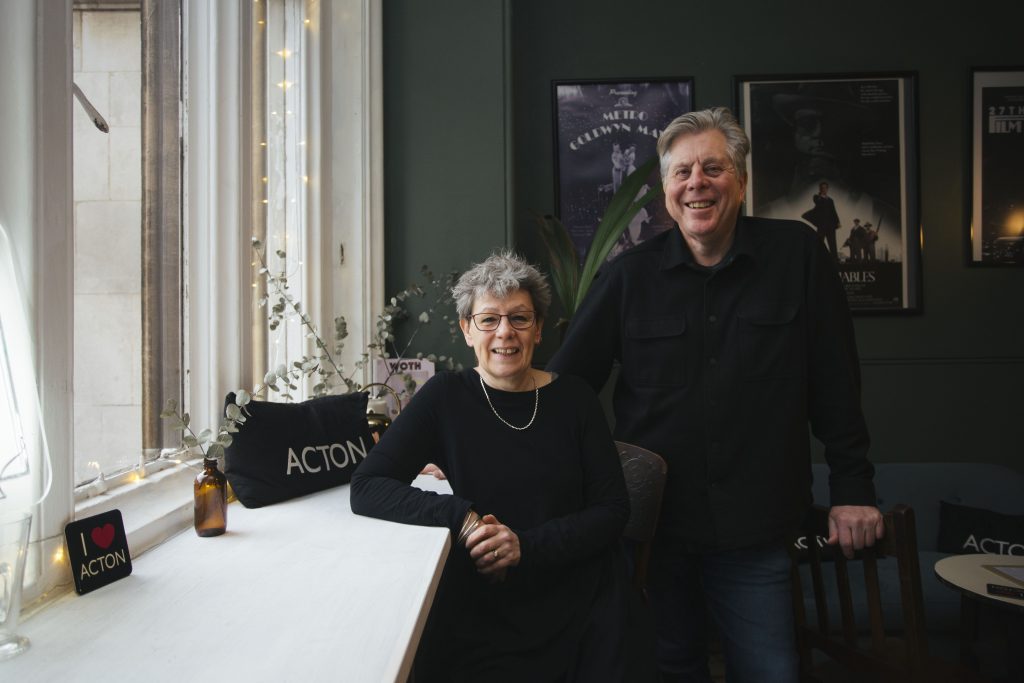 A man and a woman standing next to a window