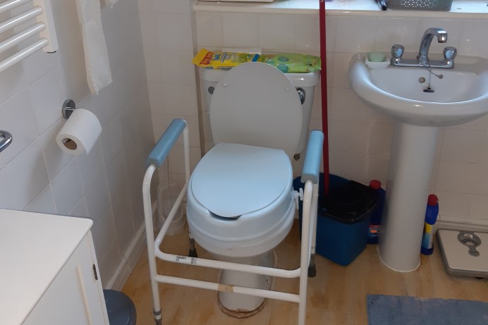 Toilet with handrails for support with washbasin 