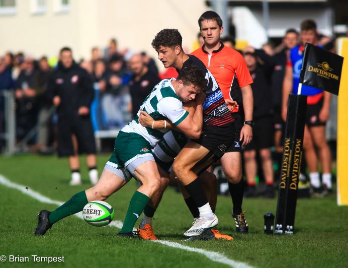 Rugby players in action - one player trying to block an opponent running with the ball