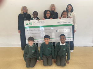 Six school pupils and three members of school staff holding a giant cheque