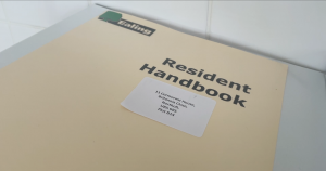 Image shows Resident Handbook with address of property on the front