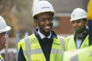Smiling man in hi-vis vest and safety helmet at a building site