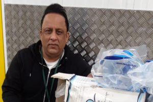 Trading standard officer Tariq Mohammed standing next to the containers of water bottles