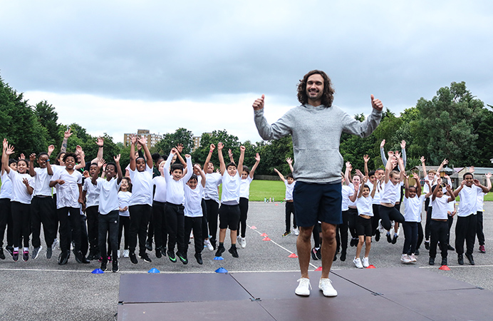 Man standing in foreground with group of school children in the background