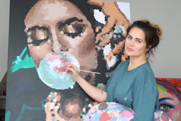 Artist Julia Nova with her art on canvas