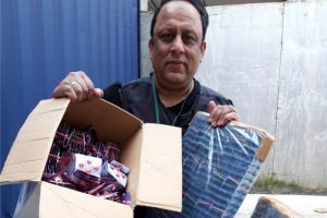 Trading standards officer Mohammed Tariq holds up a cardboard box containing the medicine in front of the storage container