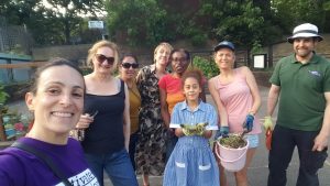 Group of smiling people holding plants