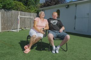 Woman and young man sitting on chairs in a garden