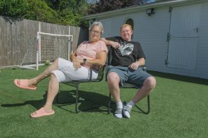 Woman and young man sitting on chairs in a garden