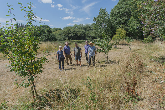 Group of people standing in a grassy enclave