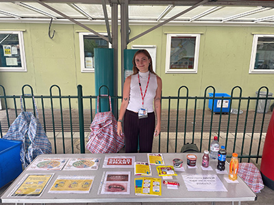 Woman standing behind table with a display of information and posters