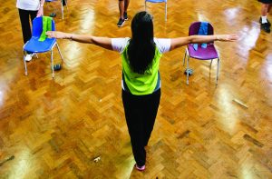 Woman holding her arms outstretched in a sports hall