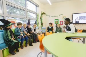 Teacher surrounded by young children in primary school classroom