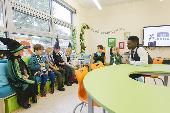 Teacher surrounded by young children in primary school classroom